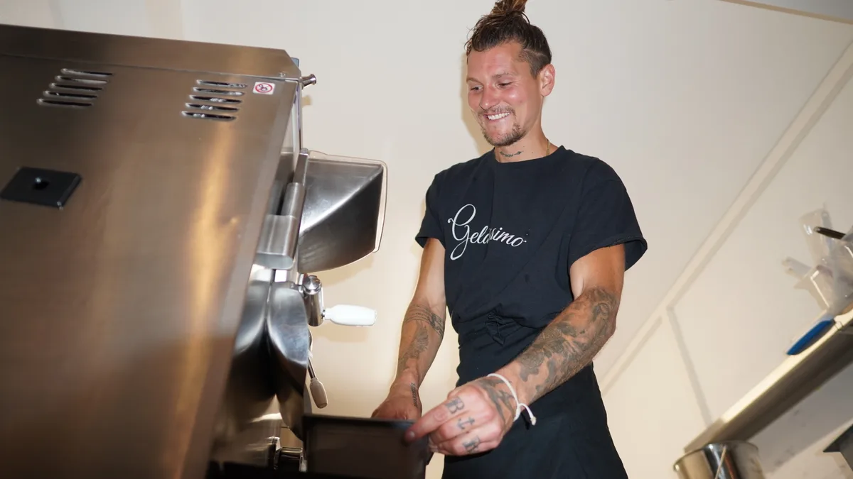 Noah Bühler schöpft Glacé aus der Maschine ab.